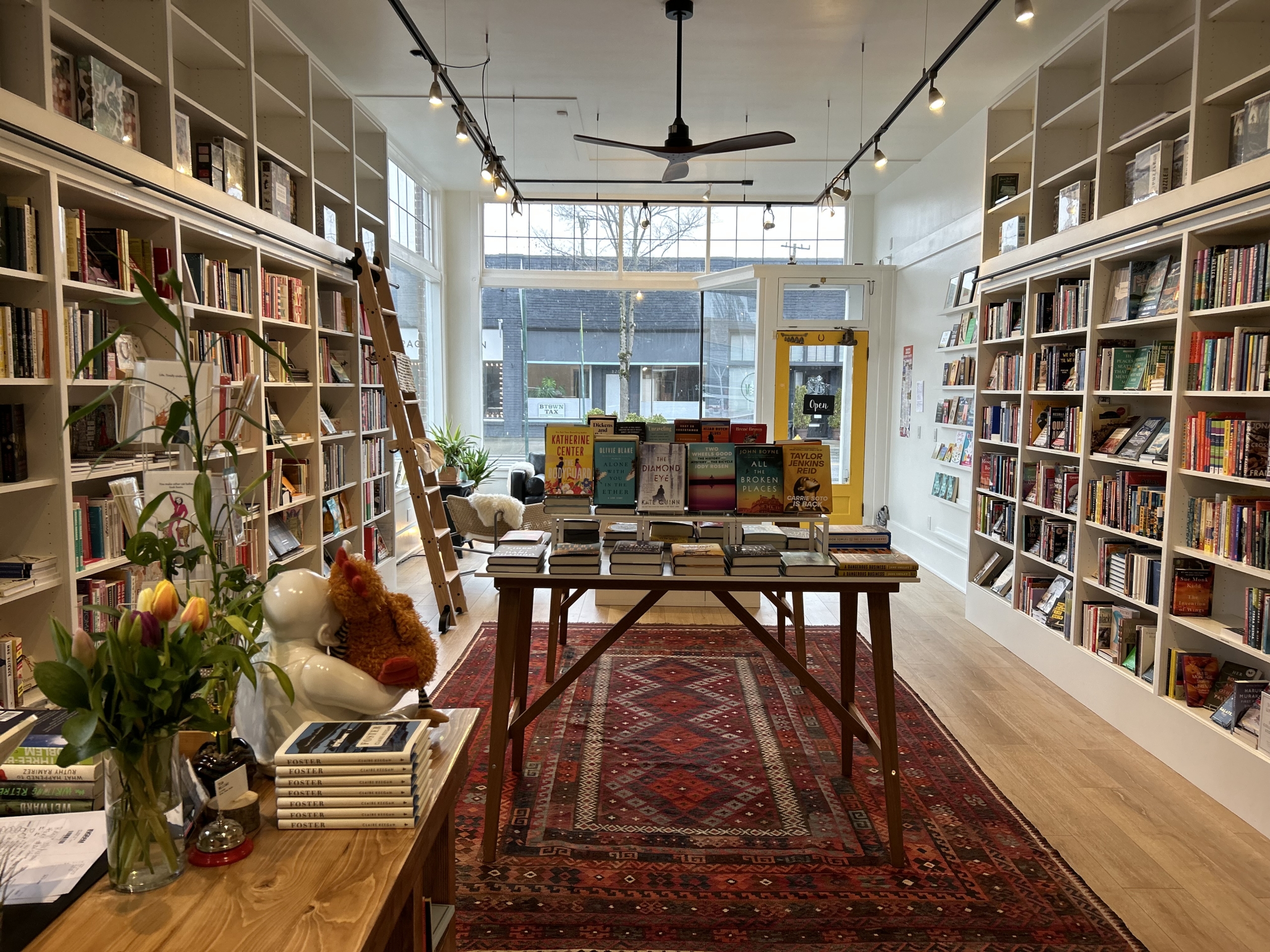 Three Trees Books interior with shelves on either side and a table in the middle with more books and gifts
