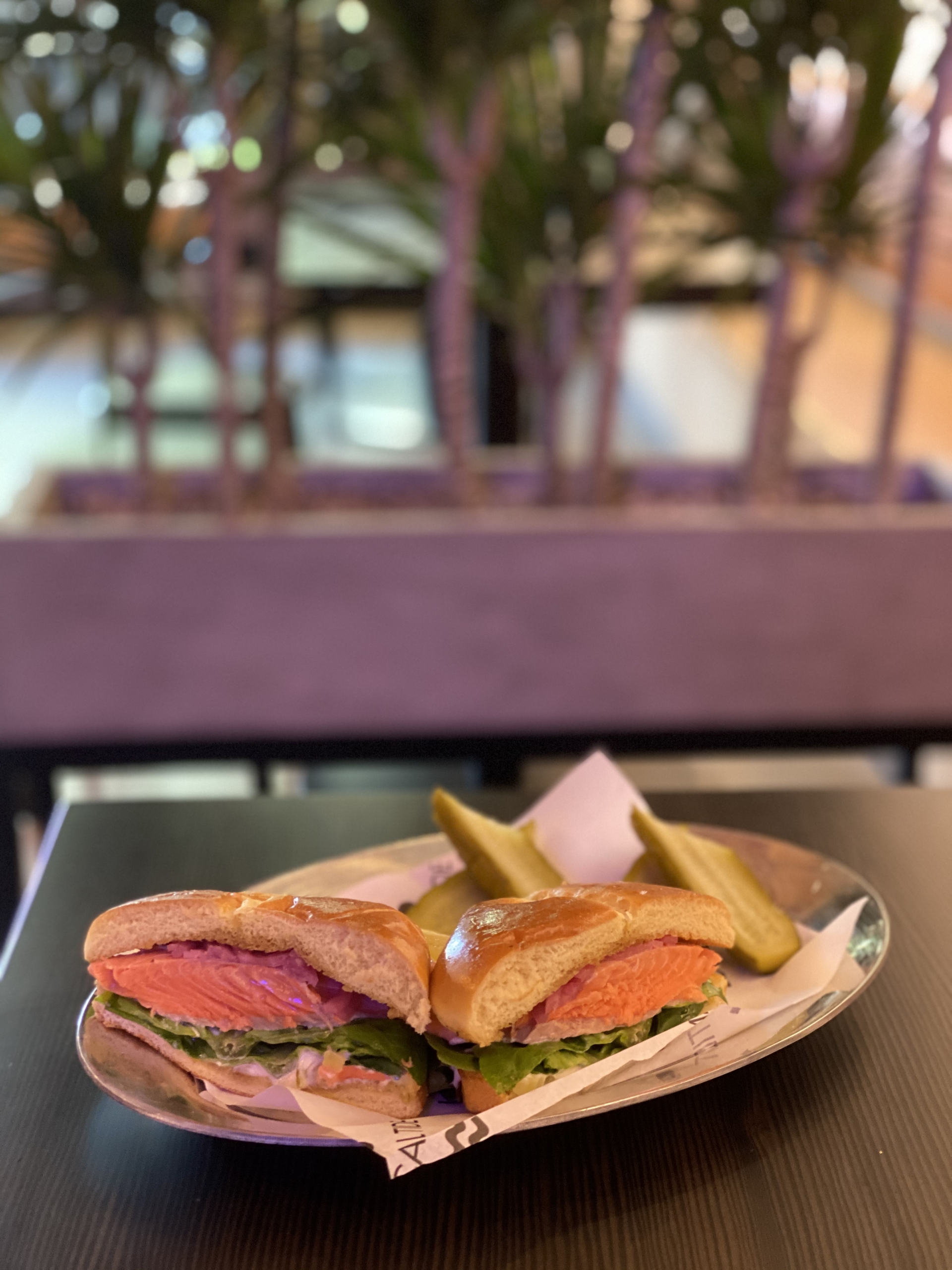 Salmon sandwich cut in half on a plate.