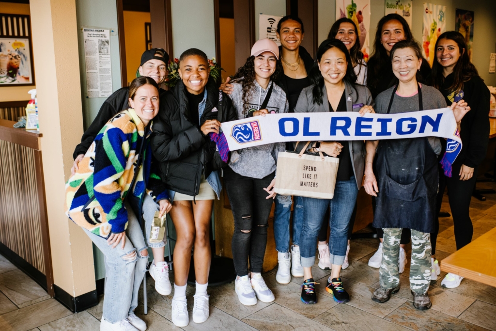 OL Reign players pose with Ping Liu of Ping's Dumpling House in Seattle's Chinatown-International District