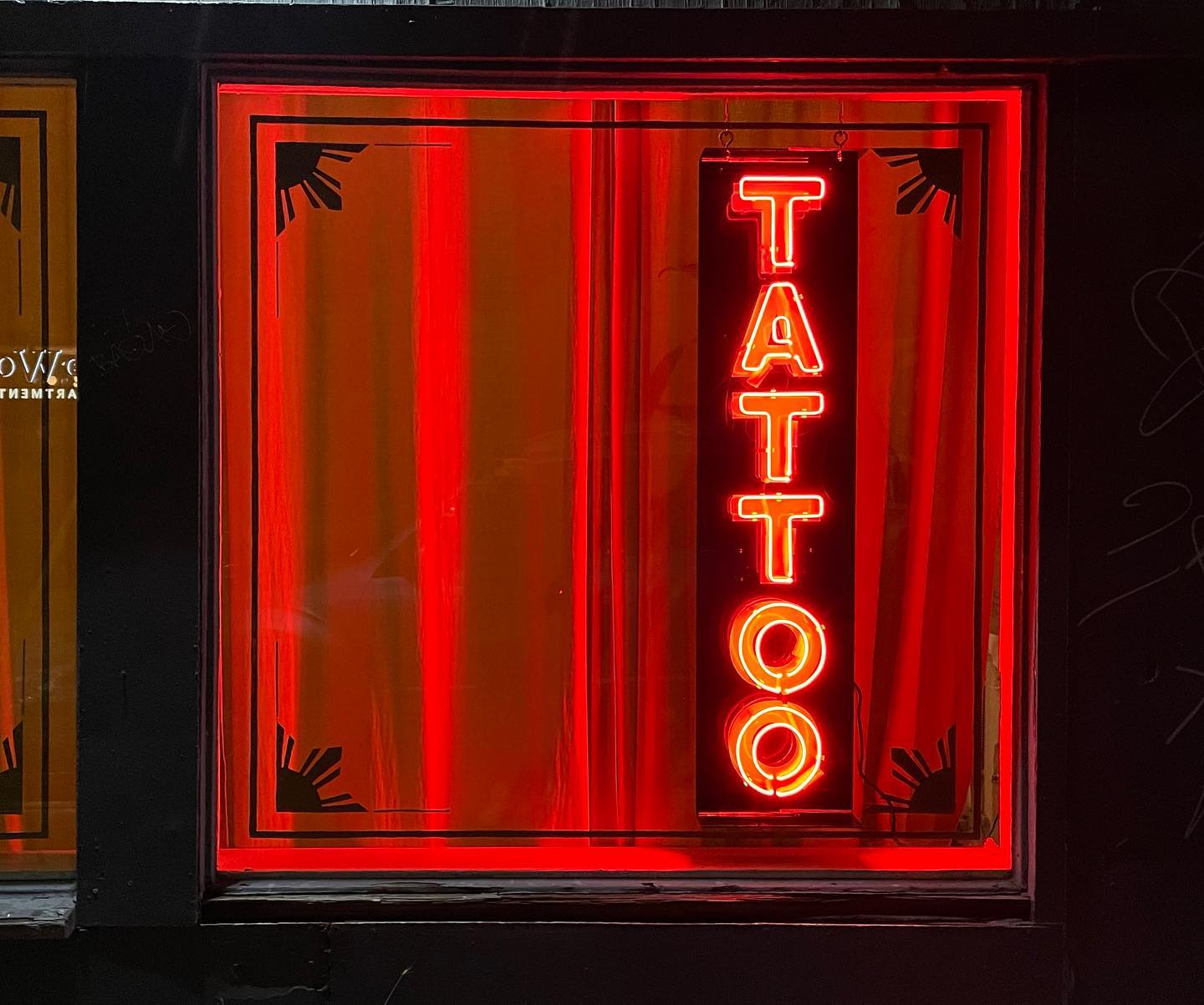 Neon signage outside tattoo parlor