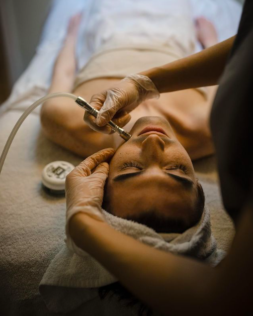 A client laying down gets a facial treatment