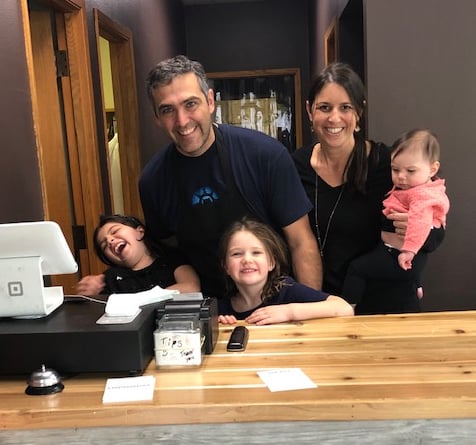 Rocky's Empanadas family photo at cash register. Husband, wife, and three young kids