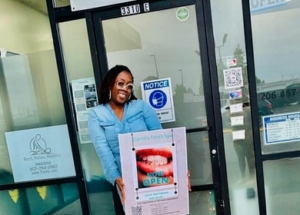 Danni's Tooth Spa owner Danni standing in front of her store with a sign saying "now open"