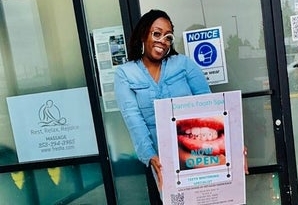 Danni's Tooth Spa owner Danni standing in front of her store with a sign saying "now open"